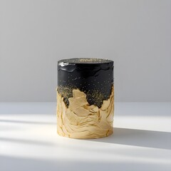 Single black and gold cake object prominently placed against a pure white background