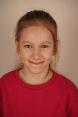 The portrait shows a close-up of a young girl's radiant smile. Her sincere childlike face radiates warmth and happiness. A touching moment, full of innocence and charm.