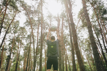 A man holding a handpan above his head in a forest, basking in the sunlight streaming through the trees. A moment of musical mindfulness in nature.