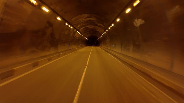 Driving inside car tunnel in mountain.