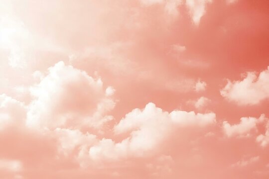 Light pale coral pink sky with white clouds. Tender peach color. Toned sunset. Elegant evening skies background. Gradient. Tropical. Summer. Sun. Romance.
