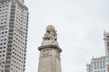 Fototapeta premium A statue between buildings in Madrid, Spain