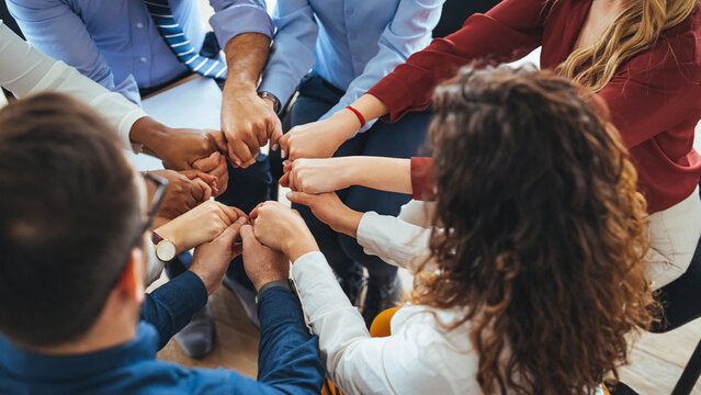 Diverse Team Members Connecting Hands in a Symbol of Unity and Support