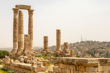 Roman ruined columns and many residential houses densily scattered on the hills in the downtown of Amman city, Kingdom of Jordan