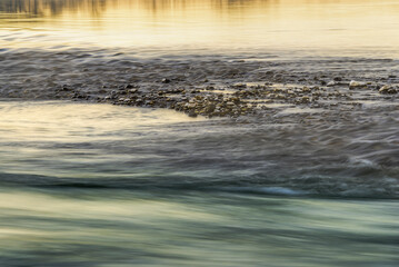 light games on the ticino river water during a winter sunrise