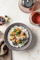 Rice porridge with banana, blueberries, chia seeds and honey sauce on a table, hot and healthy breakfast. Top view