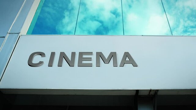 Cinema sign on a modern building with glass windows, symbolizing entertainment, movies, and cultural experiences