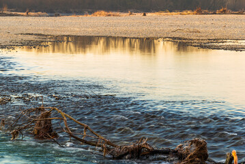 light games on the ticino river water during a winter sunrise