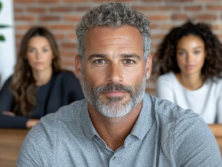 Fototapeta premium Mature Businessman and Team Portrait: Serious Expression, Office Setting
