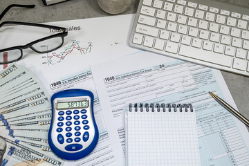 1040 us Tax forms, pen calculator and dollar money glasses on the table. Taxation, paying the tax rate. April time