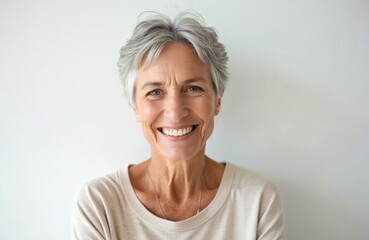 Happy mature woman portrait on white background. Cheerful face, smile and healthy skin reflects positive emotion, joy of life and inner peace. Beauty, confident and attractive look of mid age female.