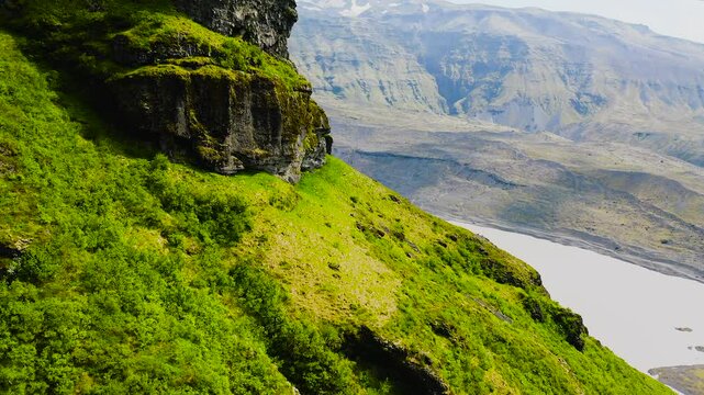 Aerial view of green mountains and glaciers next to the southern Ring Road, in Iceland.