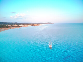 Magnificent drone areal view of sailboat on blue sea under blue skies