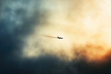 Obraz premium Airplane flying through clouds, suitable for travel or aviation related projects