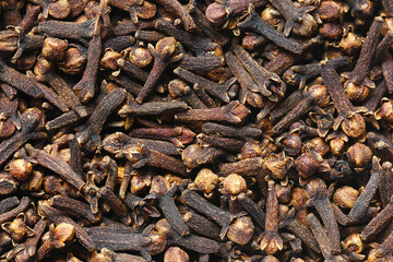 Textured surface of dried cloves in close-up. Aromatic brown spice used in cooking, seasoning and herbal medicine. Organic and flavorful ingredient with rich culinary and medicinal properties.