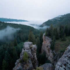 Obraz premium Misty mountaintop cliffside view, valley fog, sunrise