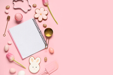 Composition with blank notebook for recipes, baking tools, Easter eggs and cookies on pink...