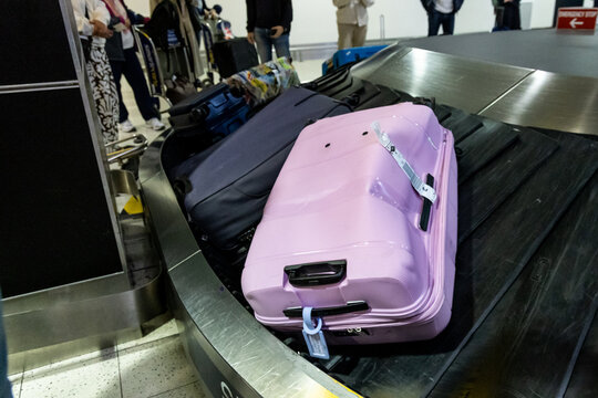 Damaged dented luggage bag circulating on airport terminal carousel conveyer belt due to rough handling along the logistic chain
