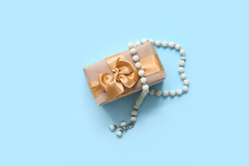 Tasbih and gift box on blue background. Ramadan celebration