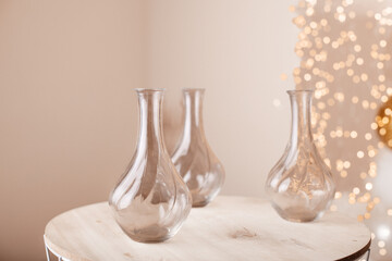 A modern minimalist table setting featuring transparent glass vases, softly illuminated by warm lights.