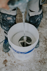 A young man washes a construction mixer.