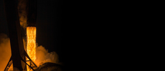 Rocket launch at night with fiery flames and smoke against a dark sky. Powerful engine burn during landing. Space shuttle rocket launch concept wallpaper. Elements of this image furnished by NASA