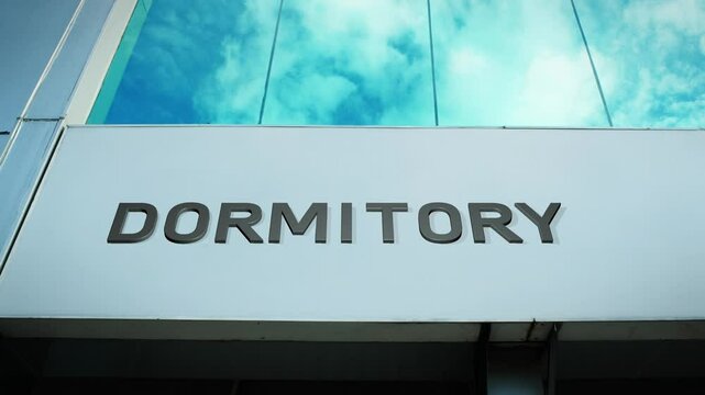 Dormitory sign on a modern building with glass windows, symbolizing student housing, accommodation, and campus living