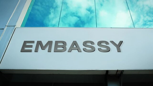 Embassy sign on a modern building with glass windows, symbolizing diplomacy, international relations, and foreign services