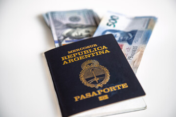 Close-up macro of Argentinean passport with dollars and Mexican pesos peeking out from the inside
