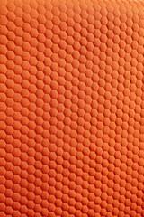 Vibrant orange fabric texture with a distinctive hexagonal pattern perfect for backgrounds textiles...