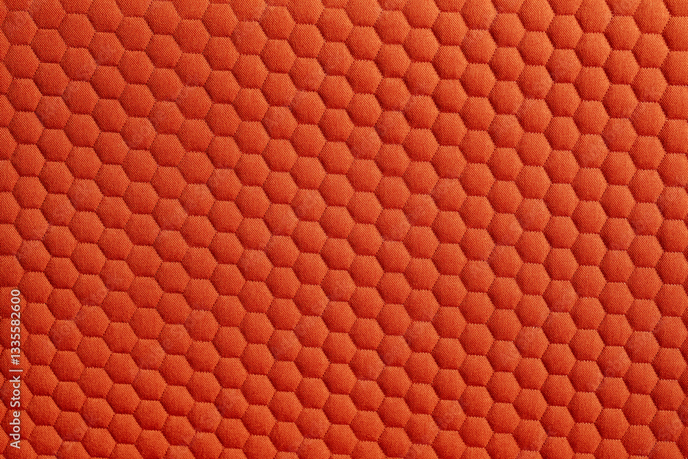 Poster close up of a vibrant orange fabric featuring a textured honeycomb pattern creating a visually appea
