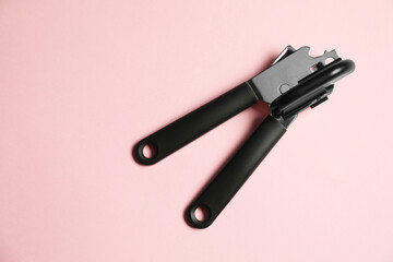 One can opener on pink background, top view. Space for text