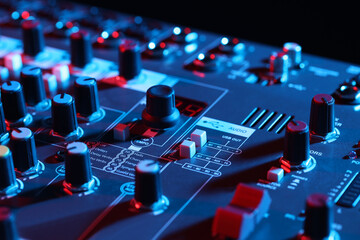 Professional mixing console on black background in neon lights, closeup
