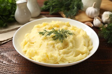 Delicious mashed potato with dill served on wooden table, closeup
