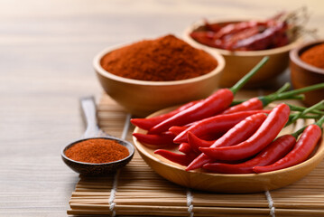 Fresh red chili peppers and chili powder on wooden background, Food ingredient