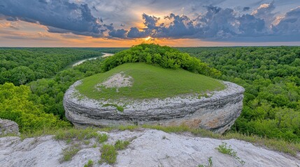 Sunset Over Lush Green Landscape with Unique Rock Formation