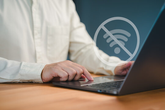Male person using a laptop computer to connect to wifi, representing internet connectivity issues, network failure, offline mode, or technology disruption.