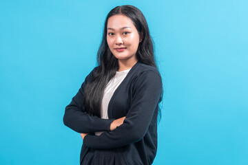 A confident Asian woman with long black hair, wearing a black cardigan over a white shirt, standing...