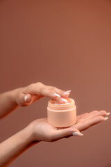 Hand-Held BB Cream Beauty Product Box on a Vibrant Orange Background