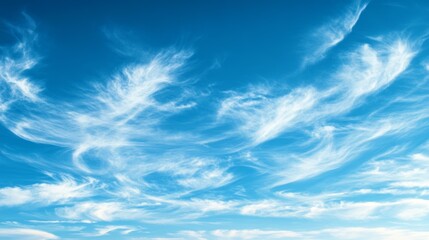 Cloud formations swirl in a bright blue sky during a clear summer day in a scenic outdoor landscape
