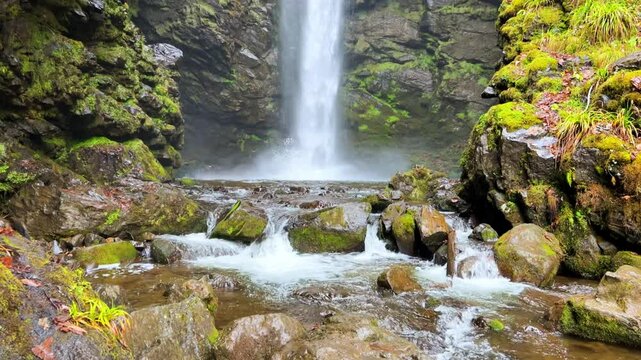 Holy waterfall of Abkhazia on a cloudy winter day in the mountains of the Caucasus. Mountain cascade waterfall. Eastern Abkhazia. Not far from the town of Tkvarcheli. Akarmara district.