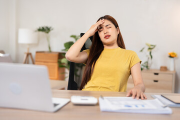 Young asian business woman feeling stress and tired from work sitting on the chair about constant...