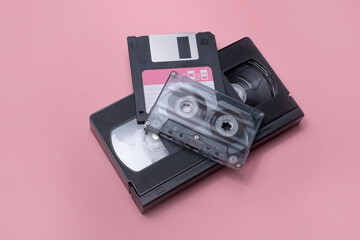 A floppy disk, VHS tape, and music cassette representing obsolete technologies from the past,...