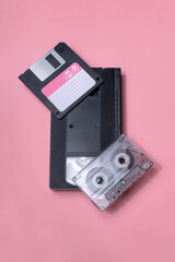 A floppy disk, VHS tape, and music cassette representing obsolete technologies from the past,...