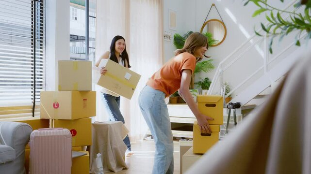 Young Asian woman moving boxes into new house, relocation and people in real estate or apartment. Moving house concept