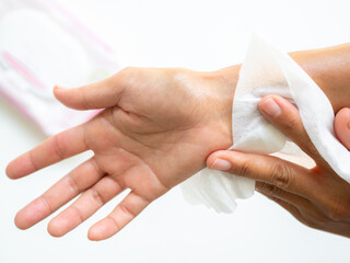 Hand woman holding wet wipe on white wall background, soft white wet tissue for clean cosmetic makeup on face or body.