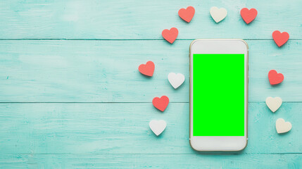 Modern smartphone surrounded by colorful hearts on a soft blue wooden surface, perfect for love-themed designs.