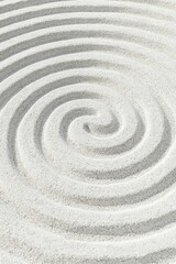 Maze pattern in white sand with a clear path to the center evokes serenity and tranquility.
