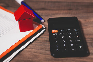 calculator, notepad and pencil on wooden table