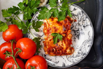 Cooking homemade lasagna from scratch. Using noodles, pasta sauce, ricotta, mozzarella cheese and Italian herbs. Boiling the noodles, browning the ground beef and layering the lasagna for a meal.